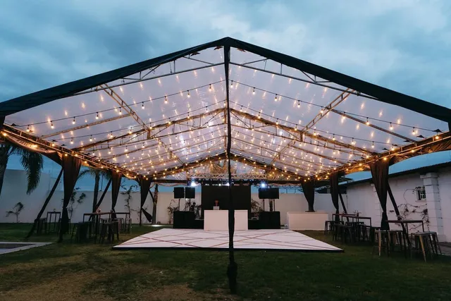 Carpa transparente iluminada en el jardín