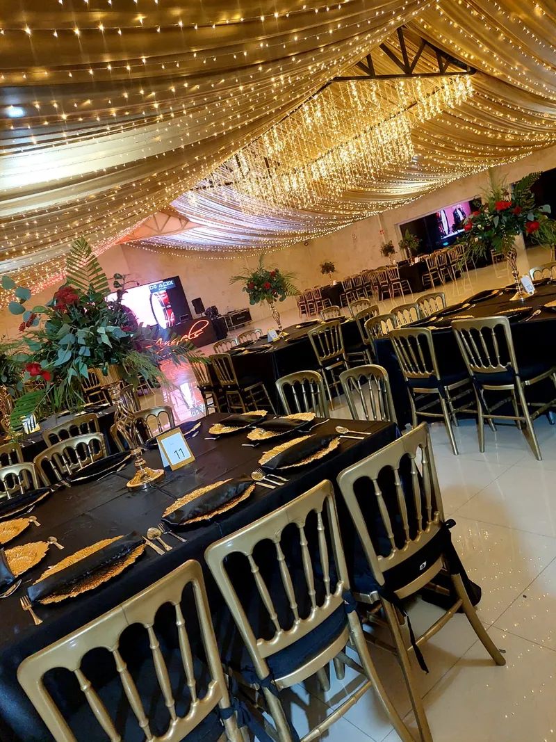 Mesas con mantel negro y sillas doradas